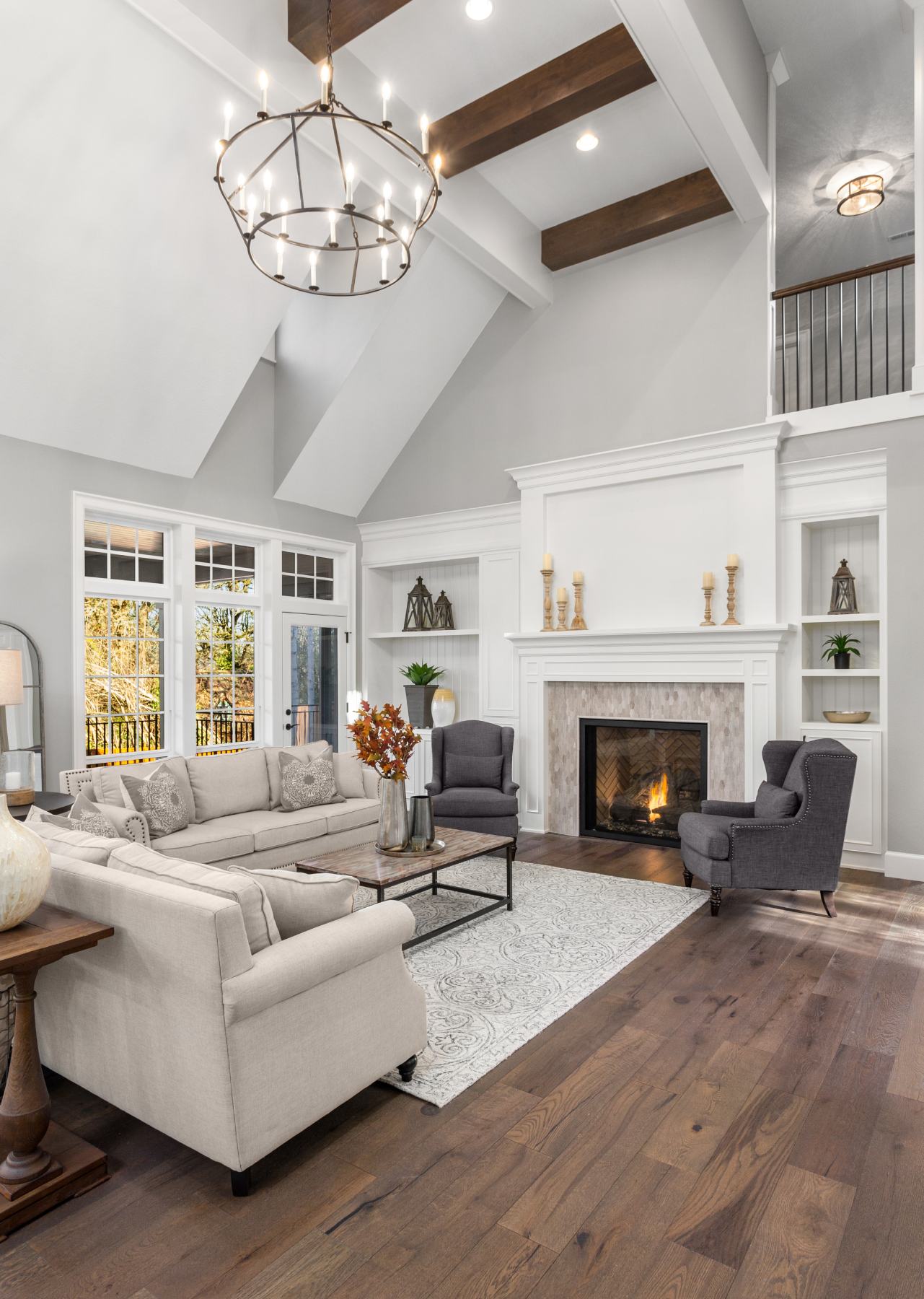 A spacious living room featuring a cozy fireplace and elegant hardwood floors.